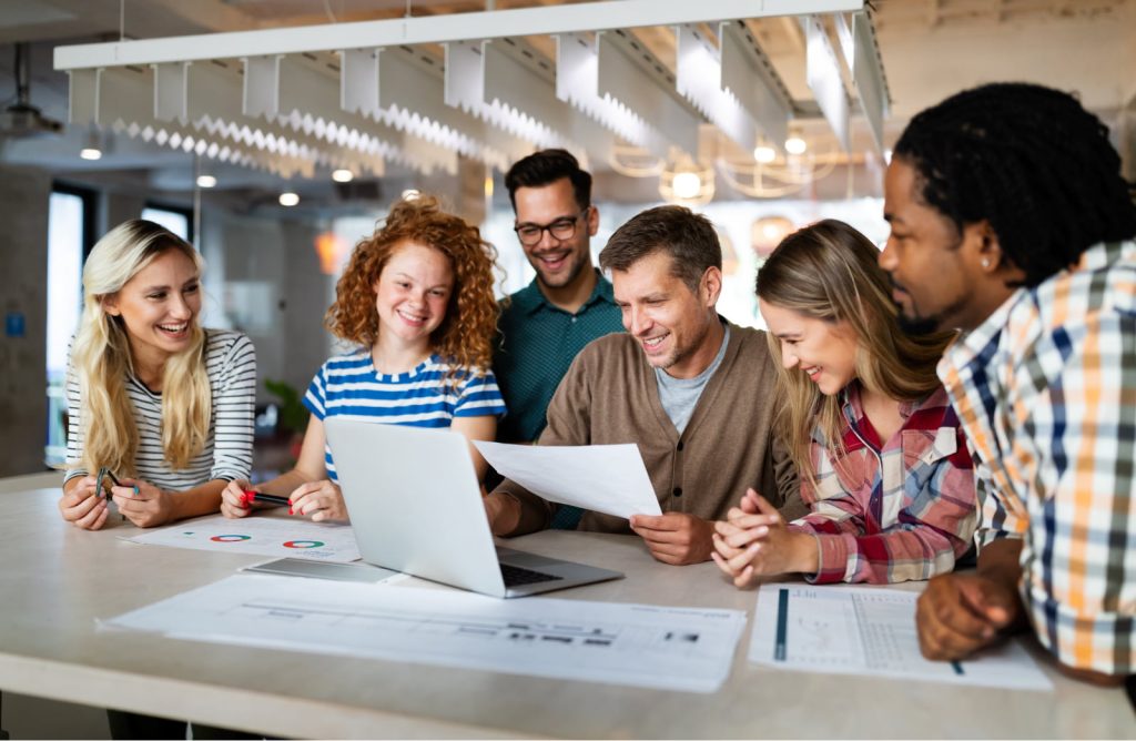 Group of young multicultural business professionals and software developers working as a team, gathered in an office.