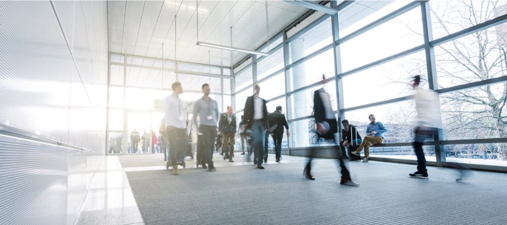 Business people walking on a modern walkway with motion blur to indicate movement.