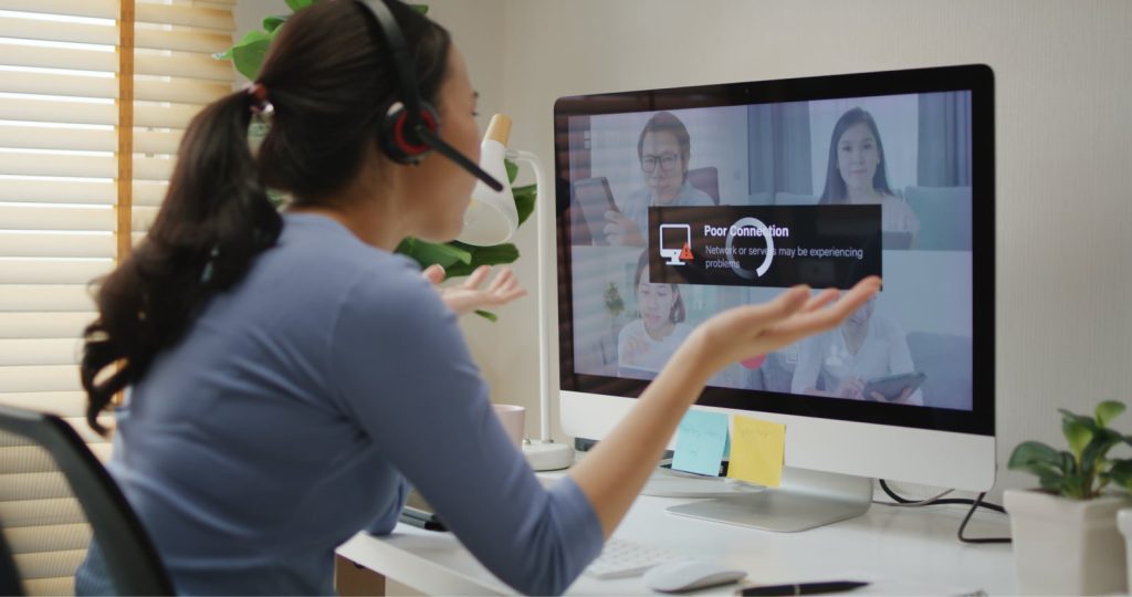 Young Asian woman stressed and frustrated at home due to poor internet connection during a video call.