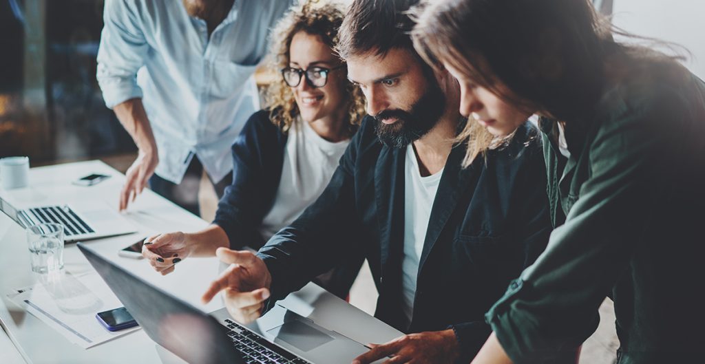 Group of young coworkers collaborating in a modern coworking studio with a blurred background.