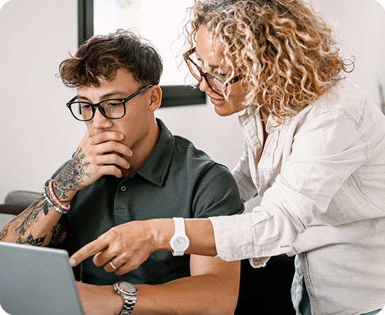 A mentor guiding a thoughtful young professional in a modern office, symbolising personalised recruitment solutions and career growth.