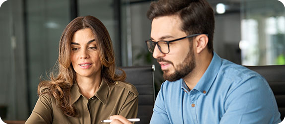 Two professionals collaborating in a modern office setting, representing banking and financial industry recruitment.