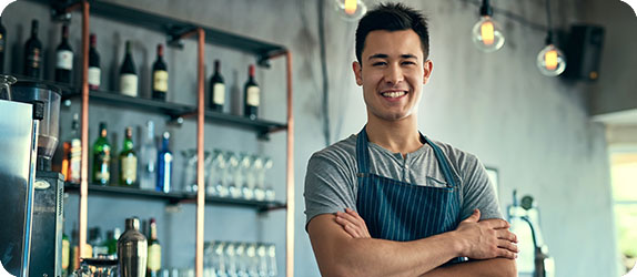 Smiling barista in a modern café, showcasing a welcoming atmosphere in the hospitality industry.