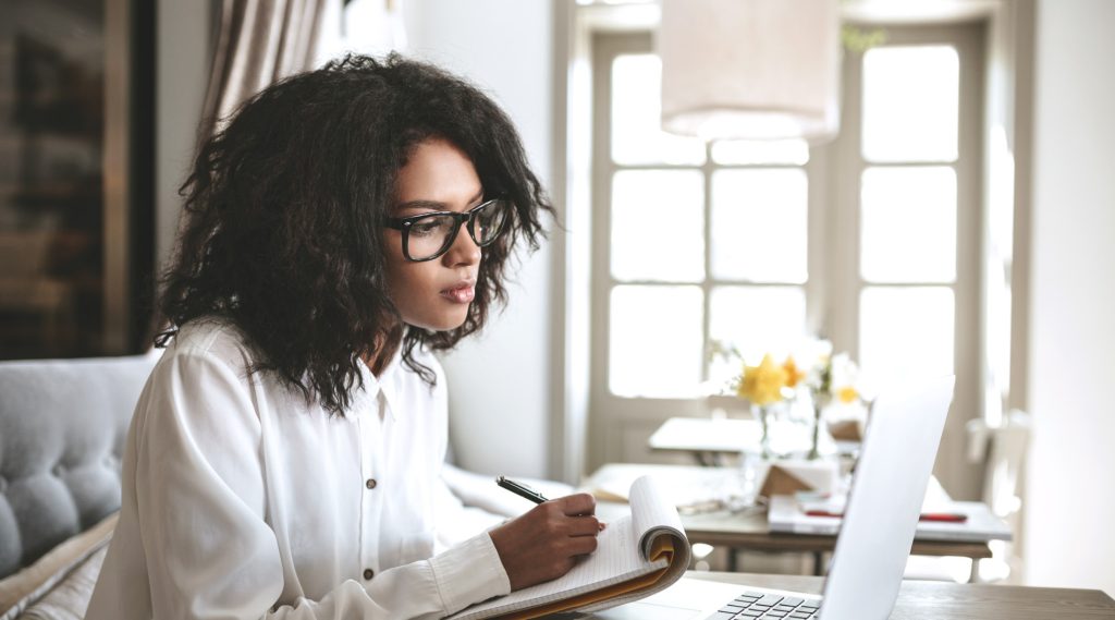 Woman taking notes from a laptop