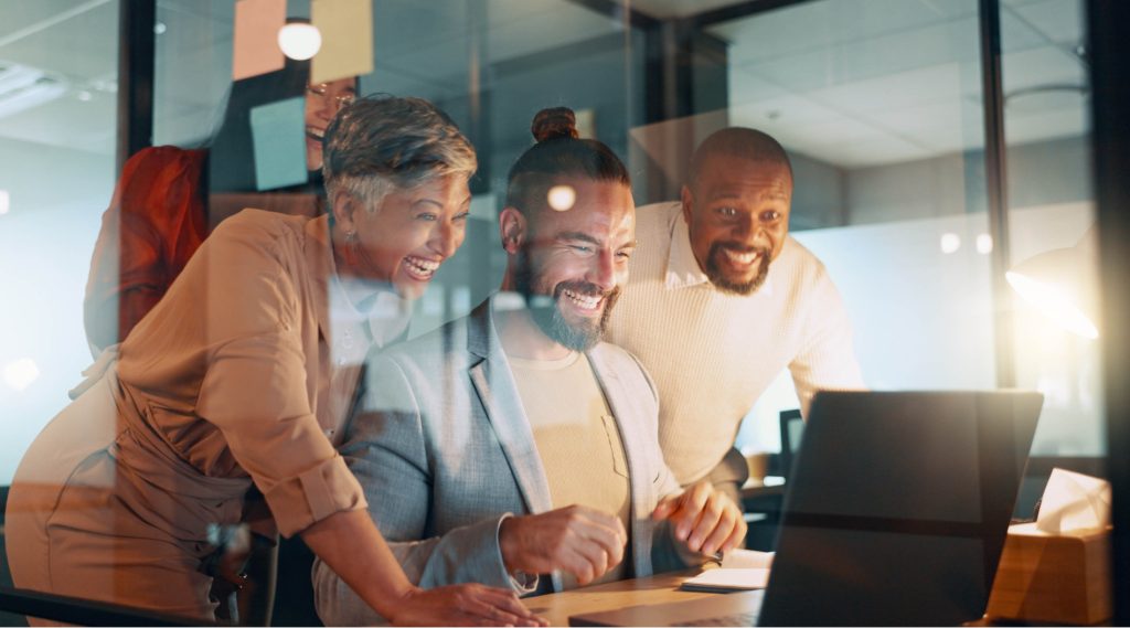 Group of people looking at a laptop with interest
