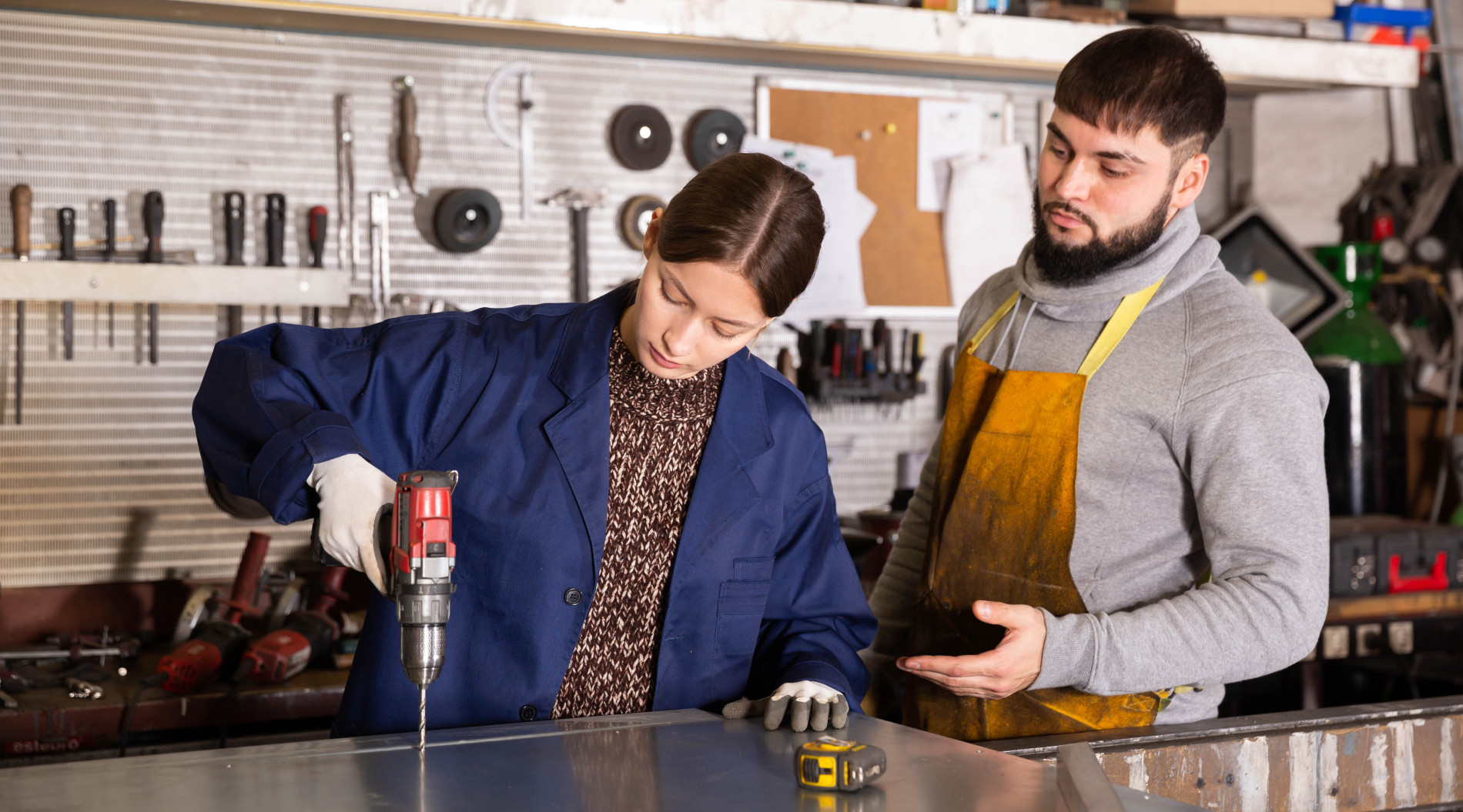 Experienced foreman teaching young workwoman
