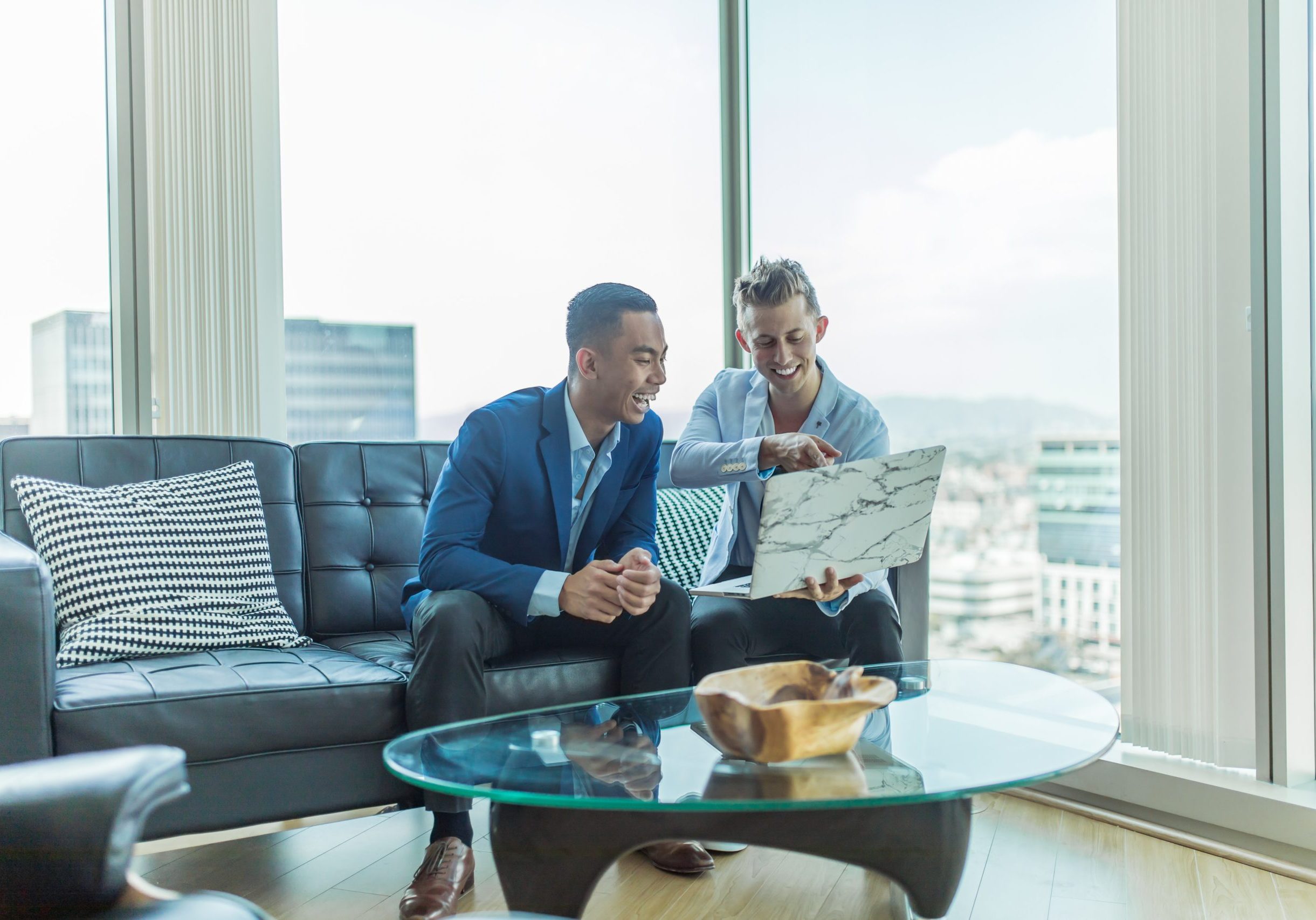 two men in suit sitting on sofa