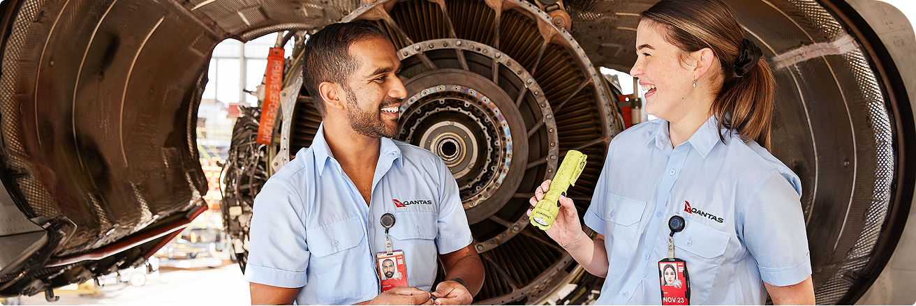 Two Qantas engineering apprentices smiling at each other