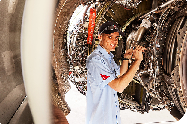 A Qantas engineering apprentice smiling at the camera