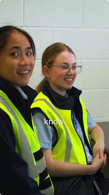 Two Qantas Engineering Apprentices in high vis smiling at looking to camera