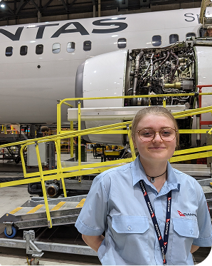 A Qantas engineering apprentice smiling at the camera