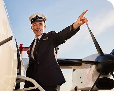 Male Qantas Pilot entering a plane and pointing out to the horizon smiling