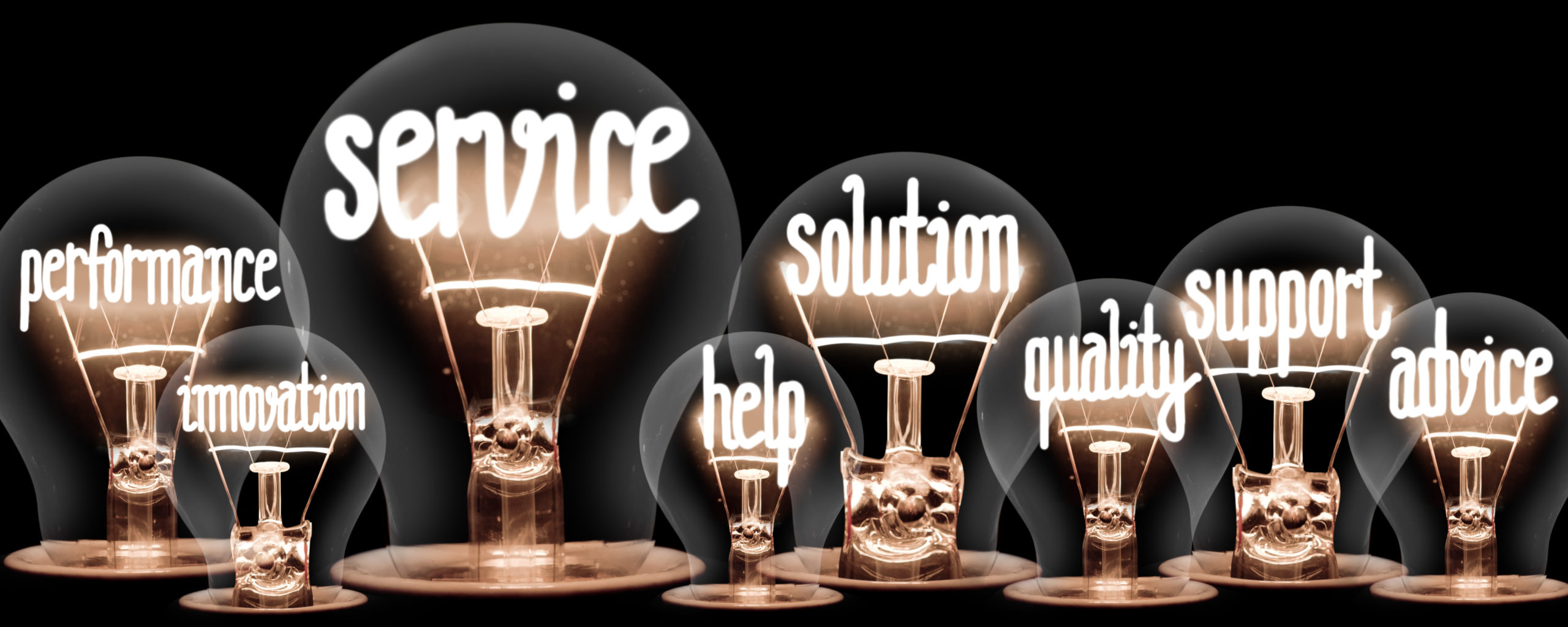 Photo of light bulbs group with shining fibers in a shape of Service, Solution, Support and Help concept related words isolated on black background