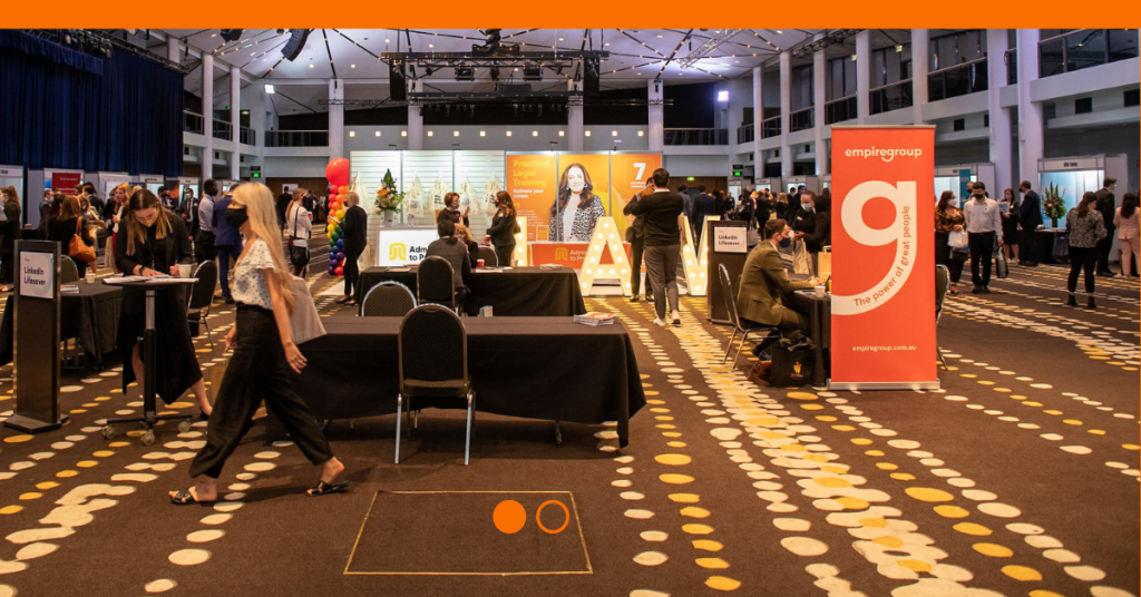 Convention setting with pull up banner featuring the 'g' empire group logo on an orange background on the right side of the image.