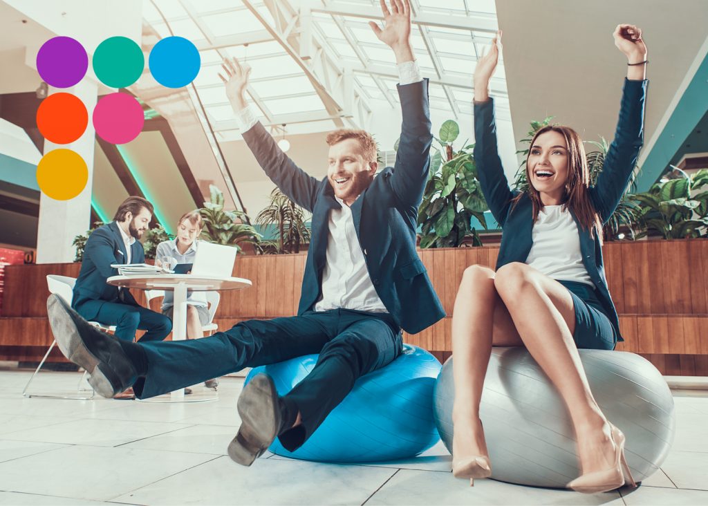 Two business people sitting on exercise balls