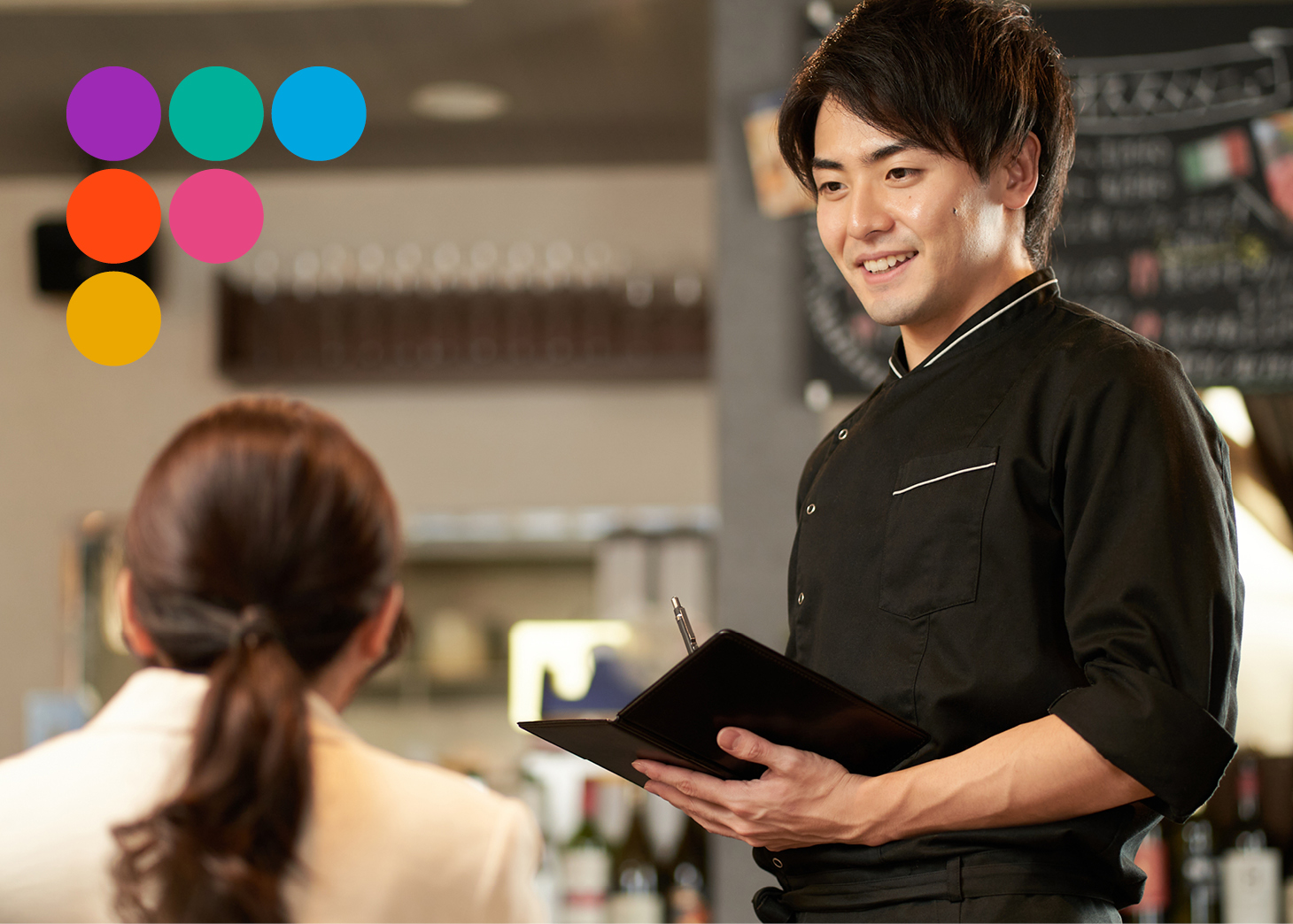 Waiter taking a customers order smiling