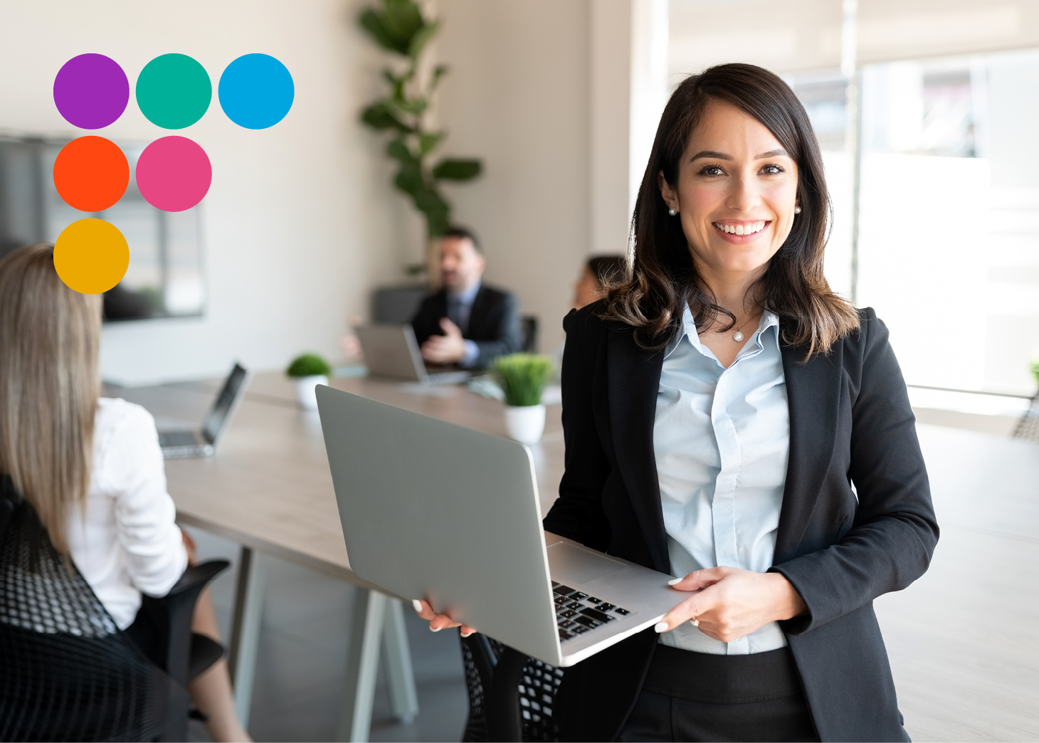 Business women holding a laptop smiling at camera