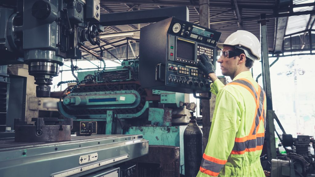 Worker using machine in factory.