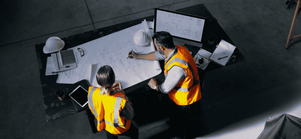 Project Engineers reviewing technical blueprints and managing construction plans for an infrastructure project in Australia.
