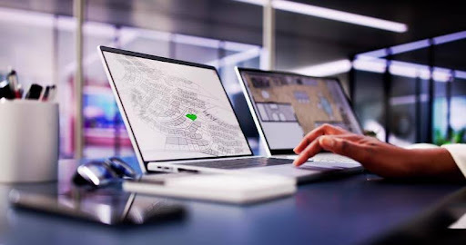 GIS professional analyzing geospatial data on a computer screen with layered maps and data visualizations