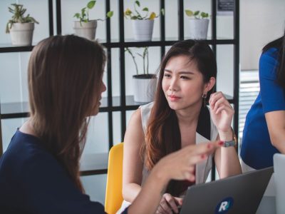 two women talking with laptop