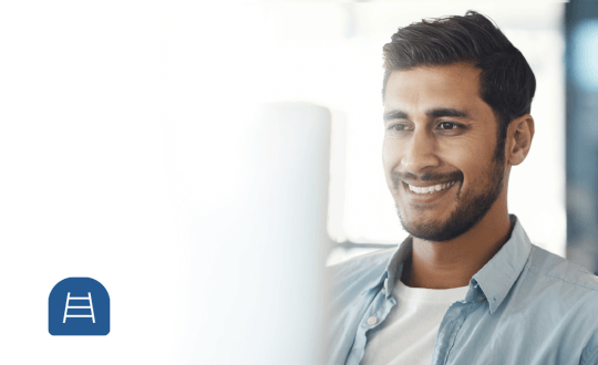Handsome man smiling and looking at computer