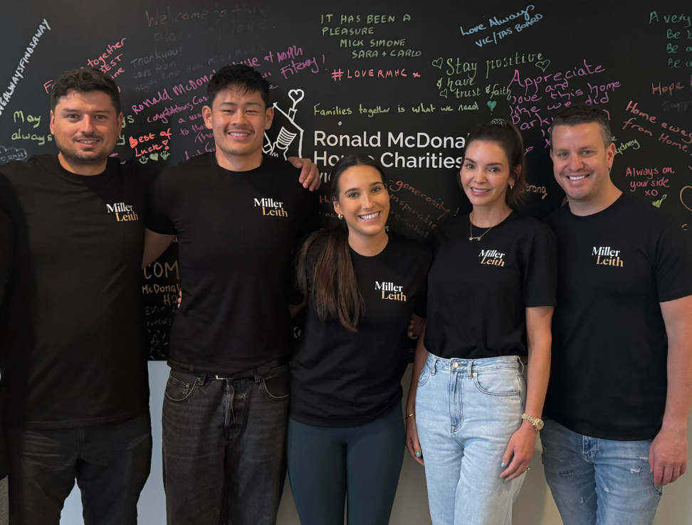 Team Standing infront of Ronald Mcdonald house charities sign.