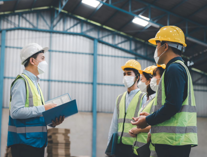 Group of HSE professionals in high vis in a factory