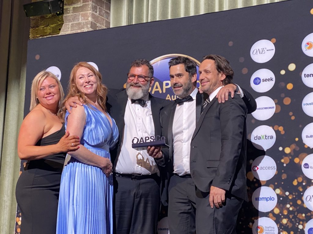 Peoplebank team on stage accepting their 2023 APSCo award win for best performance