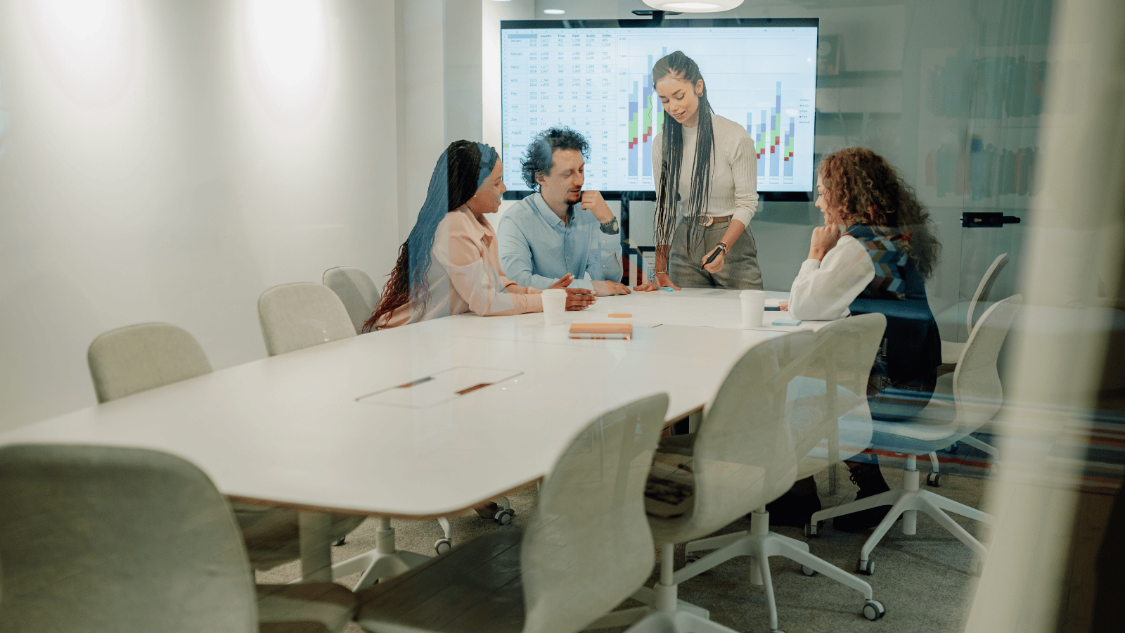 Business leaders meeting in a modern Australian site office with one empty chair representing the challenge of finding qualified HSEQ talent.