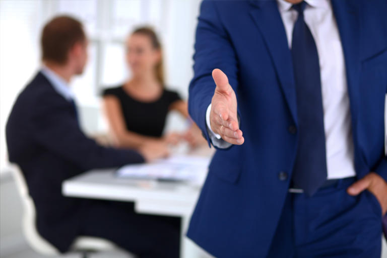 Blue suit waiting to shake hands - Talon Recruitment Solutions