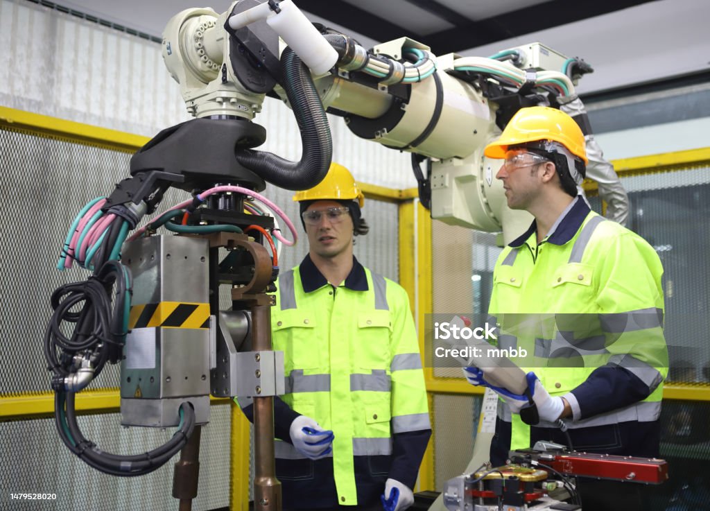 istockphoto-1479528020-1024x1024 engineer teaching robot welding machine , explanation how to working of robot arm , all function is controlled by remote