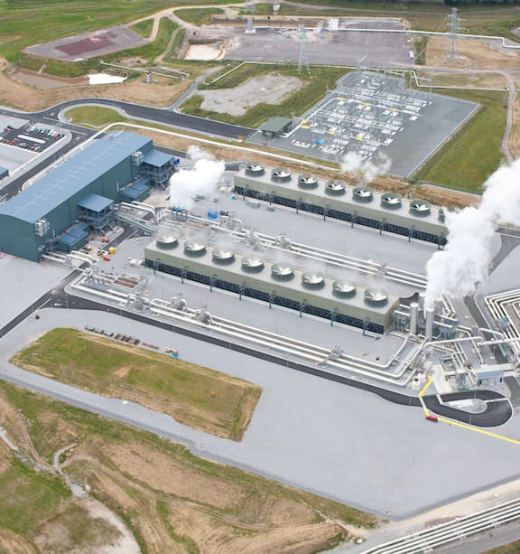 Geothermal power plant in New Zealand with steam rising from pipelines and industrial equipment, representing renewable energy engineering projects.