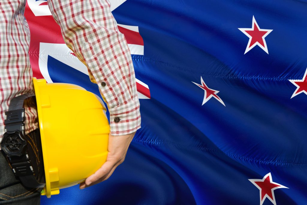 New Zealand flag with a construction hard hat, representing major engineering, infrastructure, renewable energy, data centre, and trades opportunities across New Zealand.
