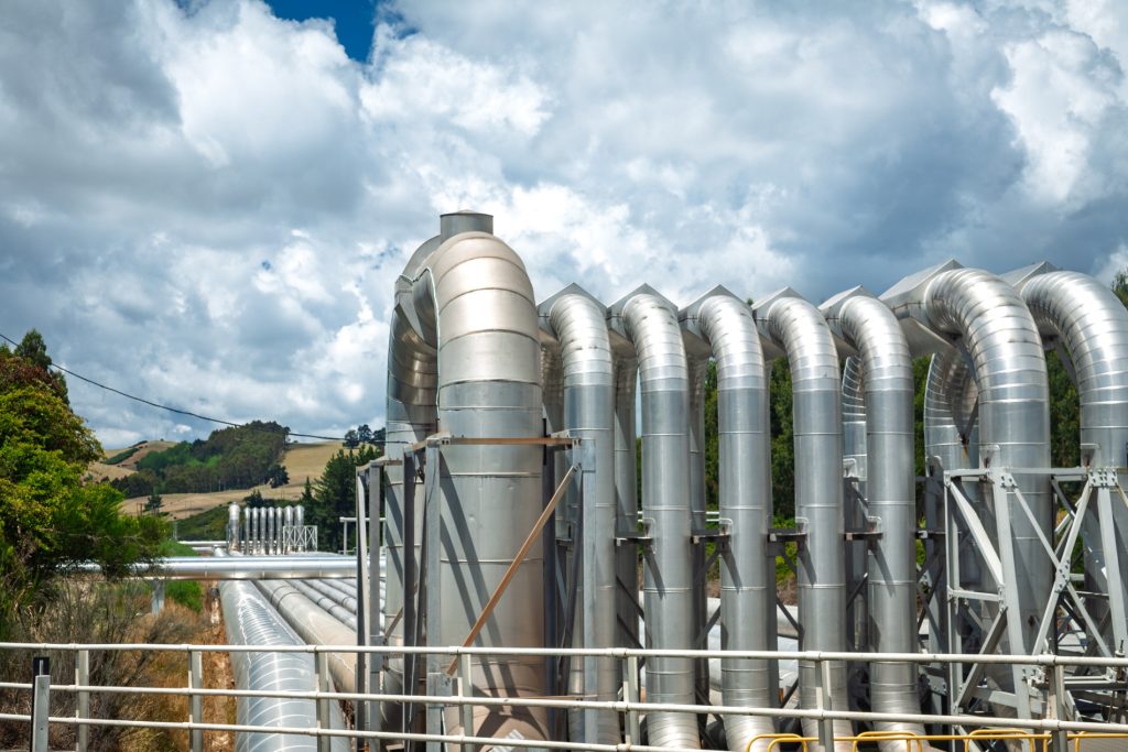 Large insulated pipelines at a geothermal energy facility in New Zealand, highlighting renewable energy infrastructure and the growing demand for skilled engineering and trades professionals.